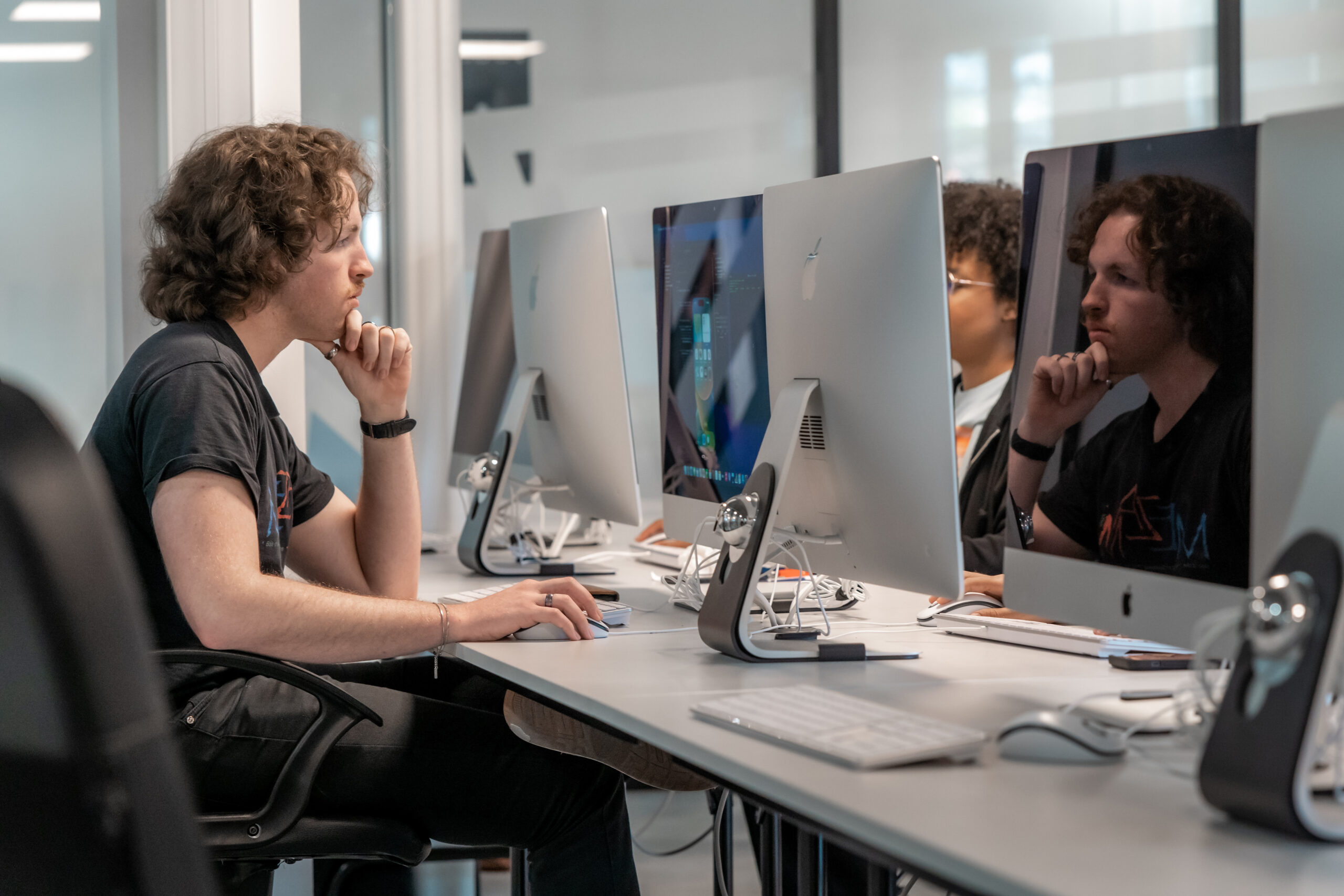 Un étudiant travaillant sur un Mac