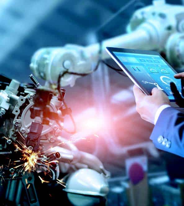 Un homme tient une tablette pour manipuler un bras de robot